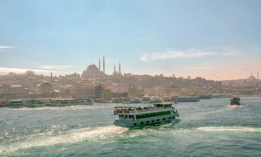 İstanbul, Türkiye 03 Nisan 2019: Türkiye'de Müslüman mimarisi ve su taşımacılığı - İstanbul Boğazı'nda deniz yolculuğundan gelen turistik manzaralar. Gün batımında İstanbul Şehir Manzarası - eski cami ve türk vapurları, Haliç manzarası.