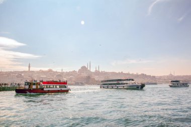 İstanbul, Türkiye 03 Nisan 2019: Türkiye'de Müslüman mimarisi ve su taşımacılığı - İstanbul Boğazı'nda deniz yolculuğundan gelen turistik manzaralar. Gün batımında İstanbul Şehir Manzarası - eski cami ve türk vapurları, Haliç manzarası.