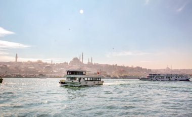 İstanbul, Türkiye 03 Nisan 2019: Türkiye'de Müslüman mimarisi ve su taşımacılığı - İstanbul Boğazı'nda deniz yolculuğundan gelen turistik manzaralar. Gün batımında İstanbul Şehir Manzarası - eski cami ve türk vapurları, Haliç manzarası.