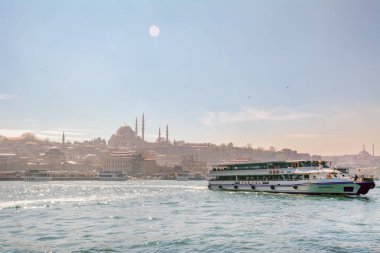 İstanbul, Türkiye 03 Nisan 2019: Türkiye'de Müslüman mimarisi ve su taşımacılığı - İstanbul Boğazı'nda deniz yolculuğundan gelen turistik manzaralar. Gün batımında İstanbul Şehir Manzarası - eski cami ve türk vapurları, Haliç manzarası.