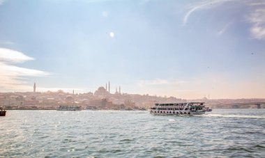 İstanbul, Türkiye 03 Nisan 2019: Türkiye'de Müslüman mimarisi ve su taşımacılığı - İstanbul Boğazı'nda deniz yolculuğundan gelen turistik manzaralar. Gün batımında İstanbul Şehir Manzarası - eski cami ve türk vapurları, Haliç manzarası.