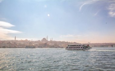 İstanbul, Türkiye 03 Nisan 2019: Türkiye'de Müslüman mimarisi ve su taşımacılığı - İstanbul Boğazı'nda deniz yolculuğundan gelen turistik manzaralar. Gün batımında İstanbul Şehir Manzarası - eski cami ve türk vapurları, Haliç manzarası.