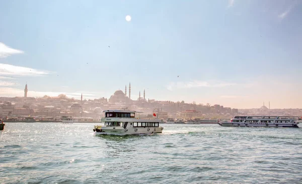 İstanbul, Türkiye 03 Nisan 2019: Türkiye'de Müslüman mimarisi ve su taşımacılığı - İstanbul Boğazı'nda deniz yolculuğundan gelen turistik manzaralar. Gün batımında İstanbul Şehir Manzarası - eski cami ve türk vapurları, Haliç manzarası.
