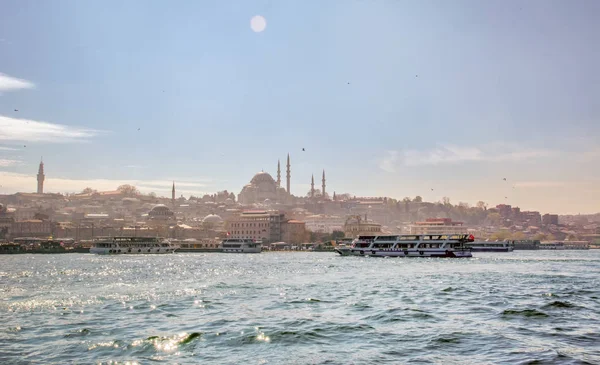 İstanbul, Türkiye 03 Nisan 2019: Türkiye'de Müslüman mimarisi ve su taşımacılığı - İstanbul Boğazı'nda deniz yolculuğundan gelen turistik manzaralar. Gün batımında İstanbul Şehir Manzarası - eski cami ve türk vapurları, Haliç manzarası.