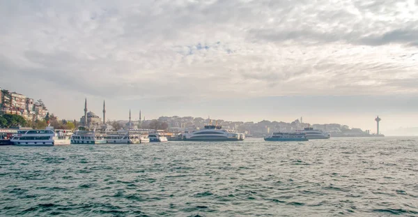İstanbul, Türkiye 03 Nisan 2019: Türkiye'de Müslüman mimarisi ve su taşımacılığı - İstanbul Boğazı'nda deniz yolculuğundan gelen turistik manzaralar. Gün batımında İstanbul Şehir Manzarası - eski cami ve türk vapurları, Haliç manzarası.