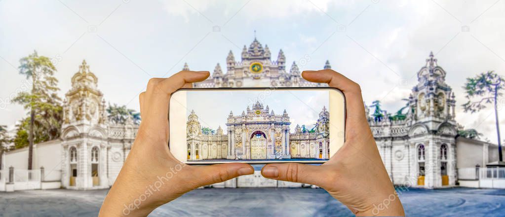 Tourist taking a picture in front of   Dolmabahce Palace Istanbul, Turkey. Travel concept