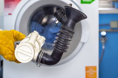 Çamaşır makinesinin drenaj pompası filtresindeki madeni paralar. Çamaşır makinesinden pompa.
