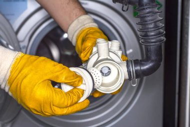 Çamaşır makinesinin drenaj pompası filtresindeki madeni paralar. Çamaşır makinesinden pompa.