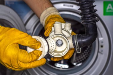 Çamaşır makinesinin drenaj pompası filtresindeki madeni paralar. Çamaşır makinesinden pompa.