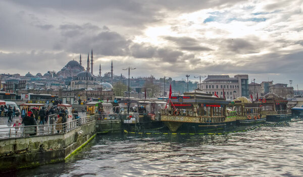 Istanbul, Turkey April 03, 2019: Muslim architecture and water transport in Turkey - Beautiful View touristic landmarks from sea voyage on Bosphorus. Cityscape of Istanbul at sunset - old mosque and turkish steamboats, view on Golden Horn.