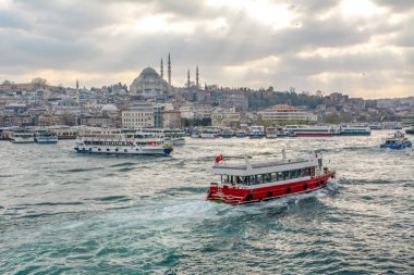 İstanbul, Türkiye 03 Nisan 2019: Türkiye'de Müslüman mimarisi ve su taşımacılığı - İstanbul Boğazı'nda deniz yolculuğundan gelen turistik manzaralar. Gün batımında İstanbul Şehir Manzarası - eski cami ve türk vapurları, Haliç manzarası.