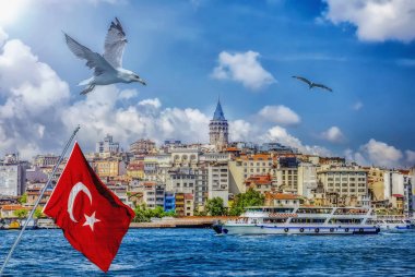 İstanbul Manzara - Galata köprüsü ve Beyoğlu ilçesinin rıhtım yakınındaki eski kentin şehir silueti. Haliç üzerinde yolcu gemileri, Türk bayrağı ve uçan kuşlar ile sahil manzarası
