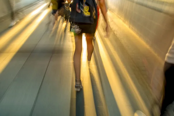 Silhuetas Pessoas Andando Túnel Escuro Contra Brilho Branco — Fotografia de Stock