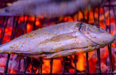 Ateş alevleri ile ızgara lezzetli balık