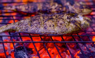 Ateş alevleri ile ızgara lezzetli balık