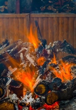 Koyu arka plan üzerinde yanmış odun ve parlak alevler