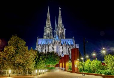Köln Katedrali 'nin Gece Manzarası (Kolner Dom) ve Ren Nehri' nin altında Hohenzollern Köprüsü, Köln şehri gökyüzü gece, Kuzey Ren Vestfalya bölgesi, Almanya.