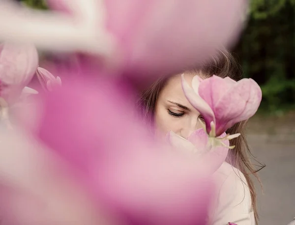 Arka planda çiçekli ağaç ile parkta dışında onu zaman zevk Çekici genç kadın.