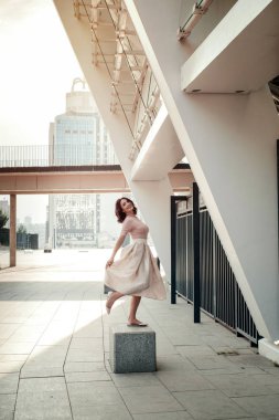 Açık giysiler giyen koyu saçlı güzel orta eged gülümseyen kadın model, yaz günü sokakta poz 