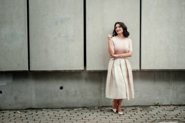 Açık giysiler giyen koyu saçlı güzel orta eged gülümseyen kadın model, yaz günü sokakta poz 