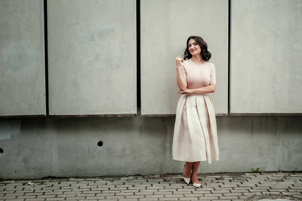 Açık giysiler giyen koyu saçlı güzel orta eged gülümseyen kadın model, yaz günü sokakta poz 