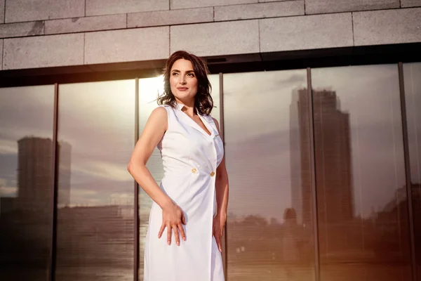 Açık giysiler giyen koyu saçlı güzel orta eged gülümseyen kadın model, yaz günü sokakta poz