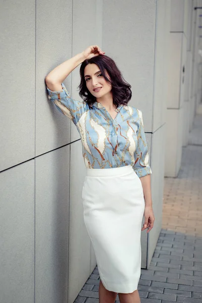 Açık giysiler giyen koyu saçlı güzel orta eged gülümseyen kadın model, yaz günü sokakta poz