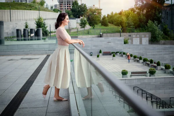 Açık giysiler giyen koyu saçlı güzel orta eged gülümseyen kadın model, yaz günü sokakta poz 