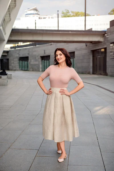 Açık giysiler giyen koyu saçlı güzel orta eged gülümseyen kadın model, yaz günü sokakta poz 