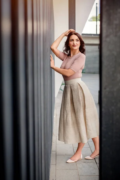 Açık giysiler giyen koyu saçlı güzel orta eged gülümseyen kadın model, yaz günü sokakta poz 