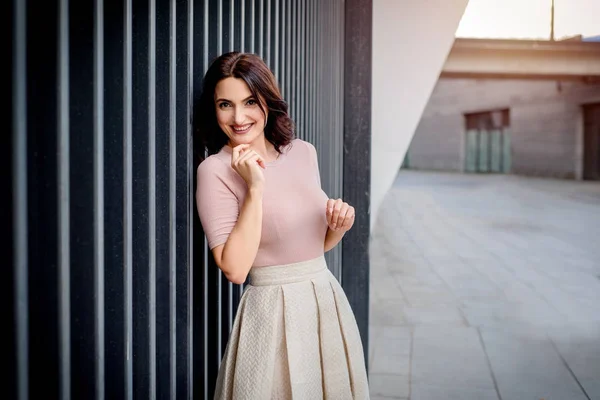 Açık giysiler giyen koyu saçlı güzel orta eged gülümseyen kadın model, yaz günü sokakta poz 