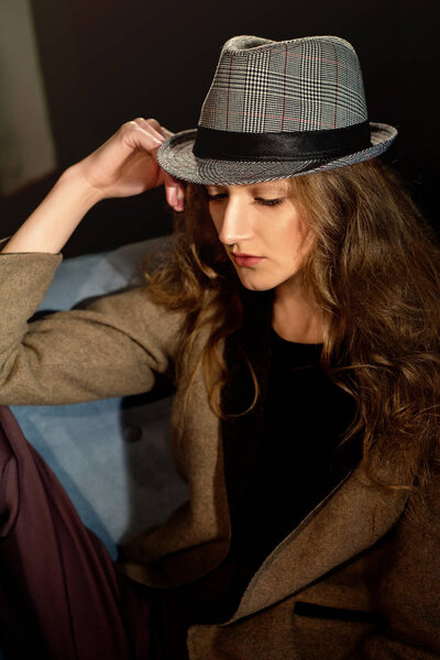 Young beautiful girl posing in hat,studio projector