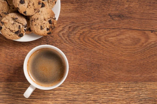 顶部的咖啡杯 配上饼干和牛角面包 放在深色的木制背景桌子上 图库图片