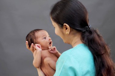 Yeni doğan bebekle oynarken neşeli Genç Anne