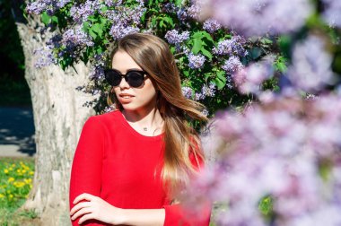 Kameraya bakarak bir mavi Lila kırmızı bir süveter giymiş bahar kız civarındadır.