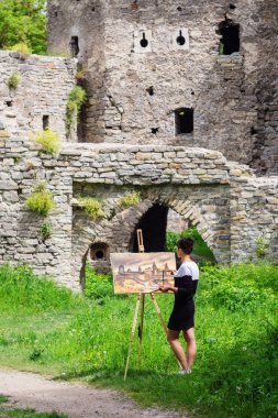 Sanatçı bir kale iş yerinde boyar. Ukrayna toprakları üzerinde bulunduğu