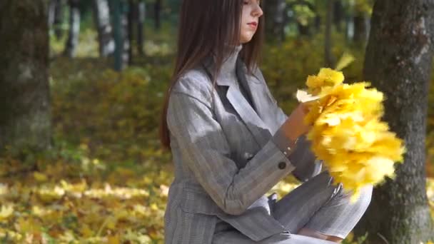 La fille est enveloppée dans une couronne de feuilles d'orange . — Video