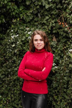 Güzel bir model kırmızı kazaklı kışın Ivy bir halkadır. Kar yağıyor. Güler yüz.