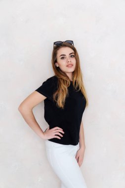 Bir stüdyoda bir kız portresi. Güzel yüzüm. Siyah T-shirt. Beyaz pantolon