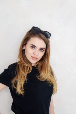 Bir stüdyoda bir kız portresi. Güzel yüzüm. Siyah T-shirt. Beyaz pantolon