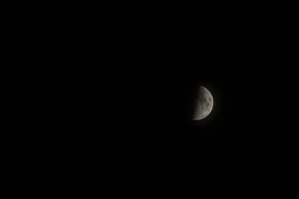 Maan in de zwarte nachtelijke hemel. — Stockfoto