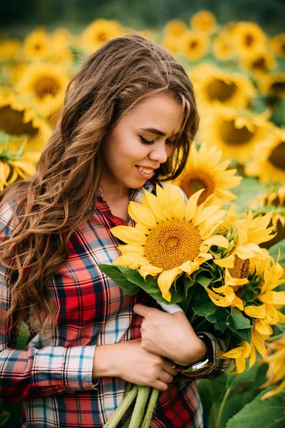 Radosna nowoczesna kobieta z słonecznymi kwiatami w polu Zdjęcia Stockowe bez tantiem