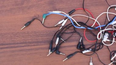 Birçok karışık kulaklık lar ahşap bir yüzey üzerinde yalan. kulaklık fişi.