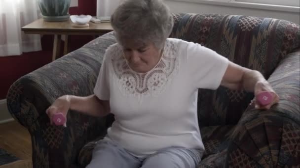 Ηλικιωμένη Γυναίκα Κάθεται Στην Καρέκλα Για Ξεκινήσετε Την Άσκηση Βαράκια — Αρχείο Βίντεο