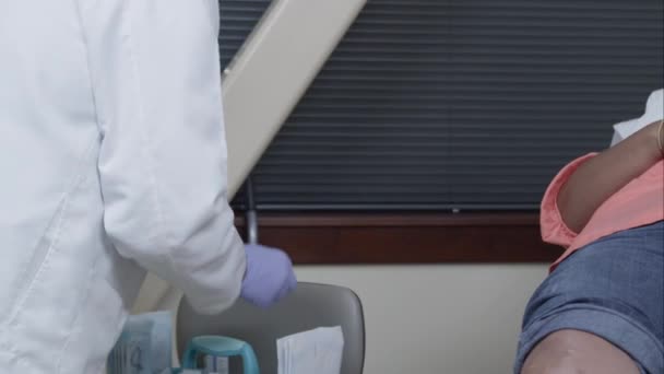 医生戴上手套 在妇女的膝盖上消毒注射部位 — 图库视频影像
