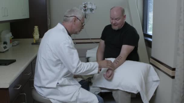 医生问候人和检查他的手臂 — 图库视频影像