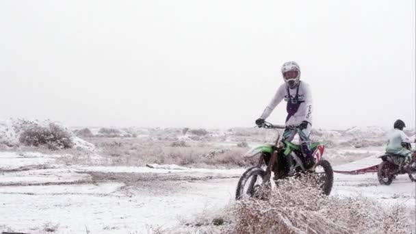 砂漠の雪の中バイクに乗る男 — ストック動画