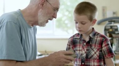 Bir çocuk bir parça tahta kum eğitmektir büyükbaba.