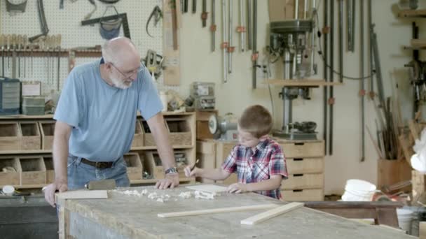 Großvater Sieht Seinem Enkel Beim Zeichnen Auf Einem Stück Holz — Stockvideo