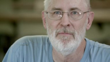 Kameraya bakarak marangozluk gözlüklü yaşlı beyefendi.